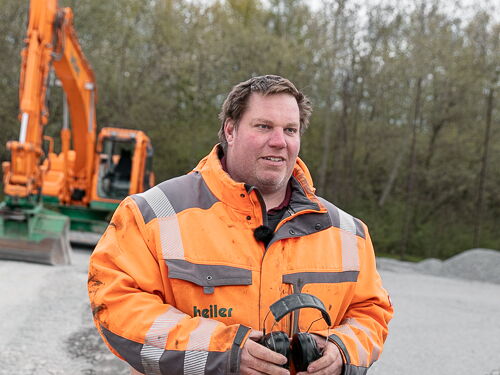 Mitarbeiter von heiler auf einer Baustelle vor einem Bagger